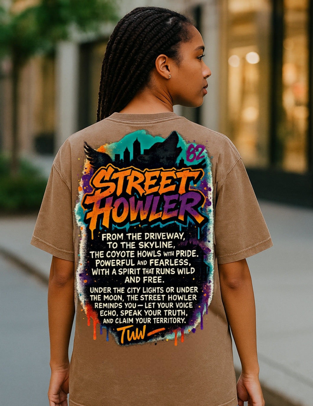 Person seen from behind wearing brown Street Howler T-shirt with colorful graphic design on back